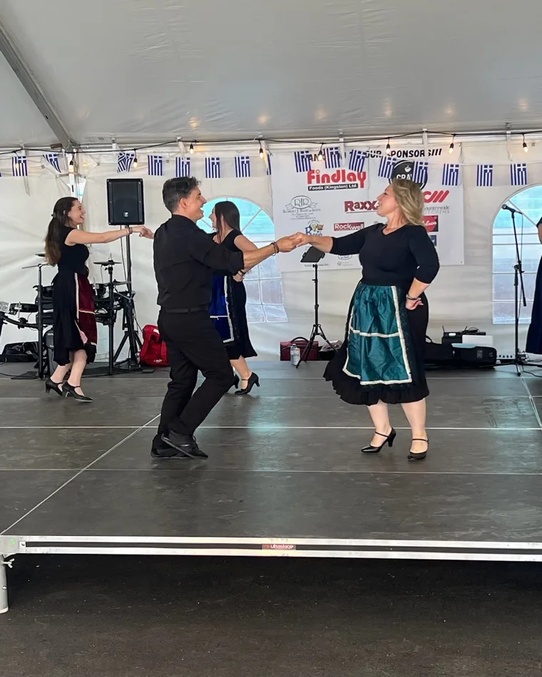 A Levendia-X couple dancing together on the Kingston Greek Fest tent stage