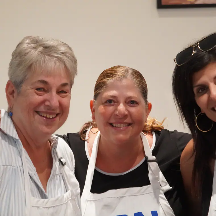 Three volunteers smiling together inside the festival hall